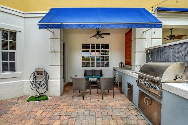 view of patio / terrace featuring ceiling fan, an outdoor living space, a sink, and area for grilling