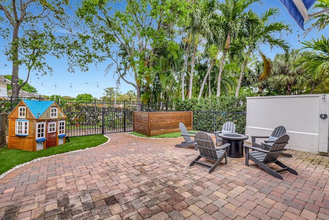 view of patio / terrace with an outdoor fire pit, an outbuilding, and fence private yard