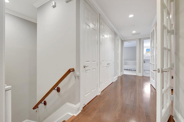 hallway featuring recessed lighting, wood finished floors, an upstairs landing, baseboards, and ornamental molding