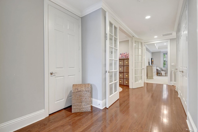 hall with baseboards, french doors, wood finished floors, and crown molding