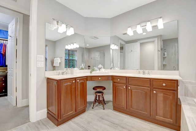 bathroom with a stall shower, a sink, a spacious closet, and double vanity