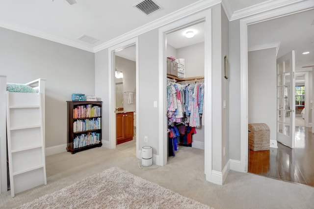 interior space with visible vents, baseboards, ornamental molding, a closet, and a walk in closet