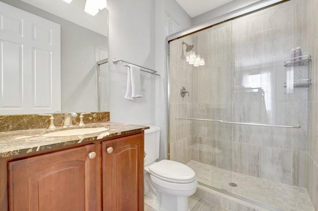 full bathroom with a stall shower, vanity, and toilet