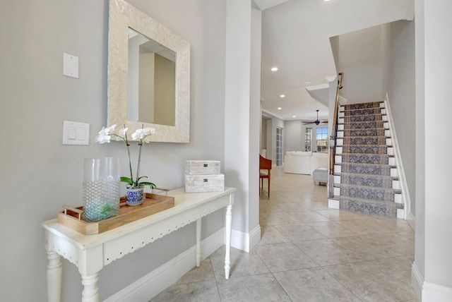 tiled foyer featuring ceiling fan, stairs, baseboards, and recessed lighting