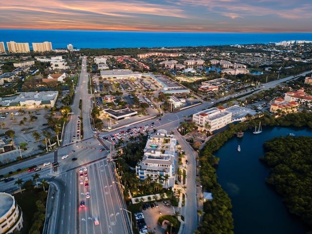 aerial view at dusk featuring a water view