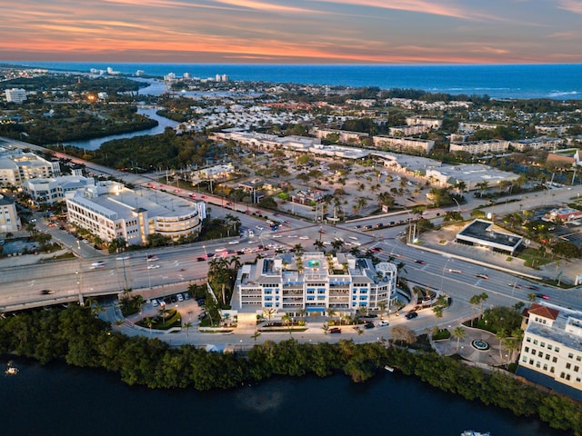 aerial view at dusk featuring a water view