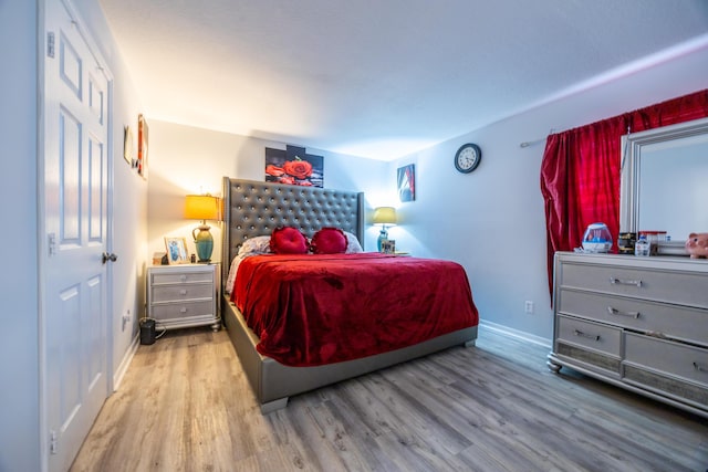 bedroom featuring baseboards and wood finished floors