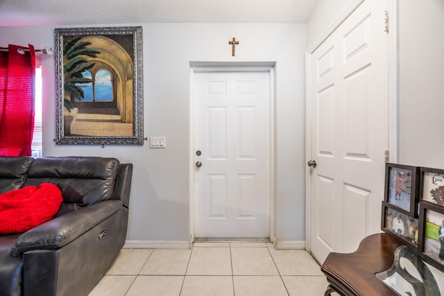 foyer entrance featuring baseboards and light tile patterned floors