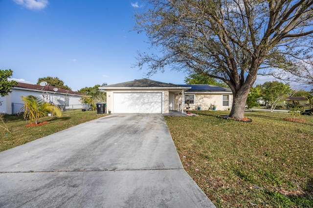 ranch-style home with stucco siding, roof mounted solar panels, a garage, driveway, and a front lawn