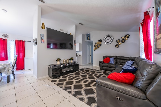 tiled living room featuring lofted ceiling, visible vents, and baseboards