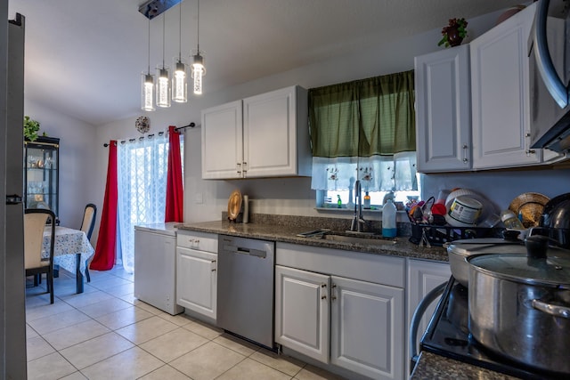 kitchen featuring dishwasher, light tile patterned floors, a sink, and white cabinetry