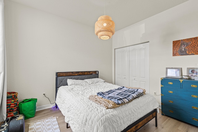 bedroom with a closet, baseboards, and wood finished floors