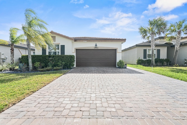 view of front of property featuring a garage, a front yard, decorative driveway, and stucco siding