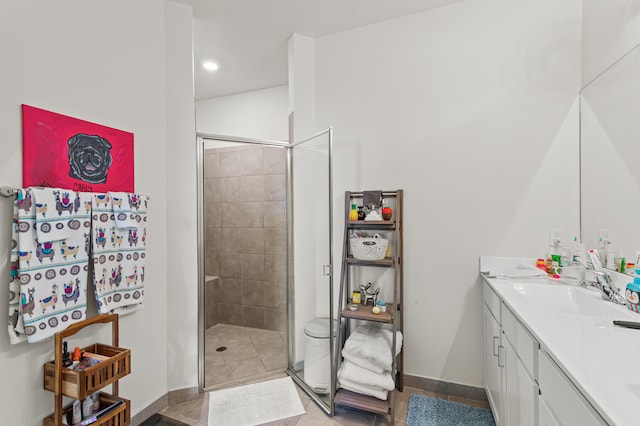 bathroom featuring a sink, baseboards, a shower stall, tile patterned floors, and double vanity