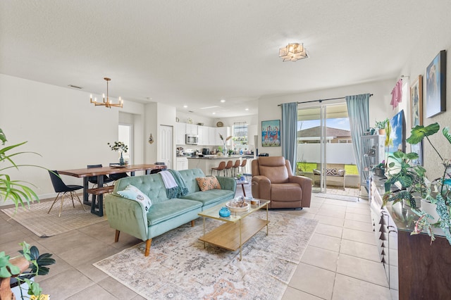 living area featuring light tile patterned floors, baseboards, a textured ceiling, a notable chandelier, and recessed lighting