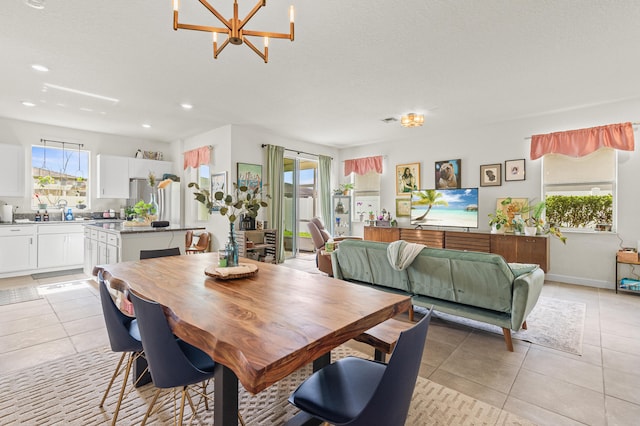 dining room with light tile patterned floors, recessed lighting, a textured ceiling, a chandelier, and baseboards