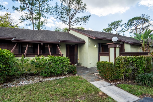 view of front of property with roof with shingles and stucco siding