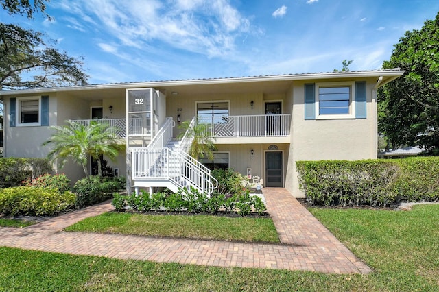 view of front of home featuring stucco siding and stairs