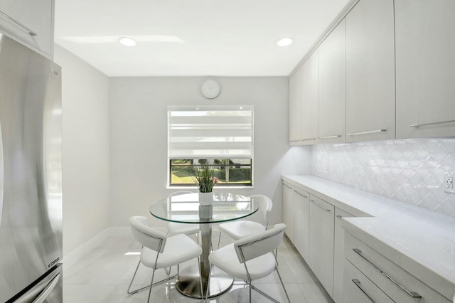 dining room with recessed lighting, light tile patterned flooring, and baseboards