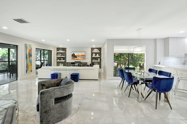 living area with recessed lighting, marble finish floor, visible vents, and plenty of natural light