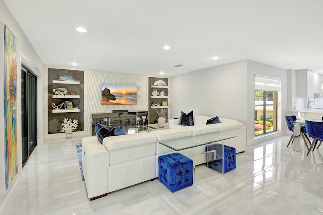 living room featuring marble finish floor, built in shelves, and recessed lighting