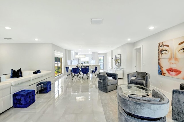 living area featuring recessed lighting, visible vents, and baseboards