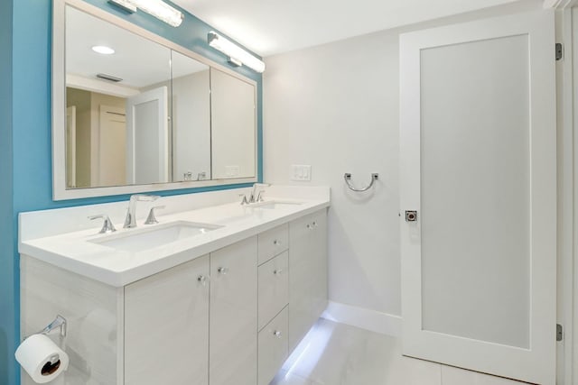 bathroom with double vanity, a sink, visible vents, and tile patterned floors