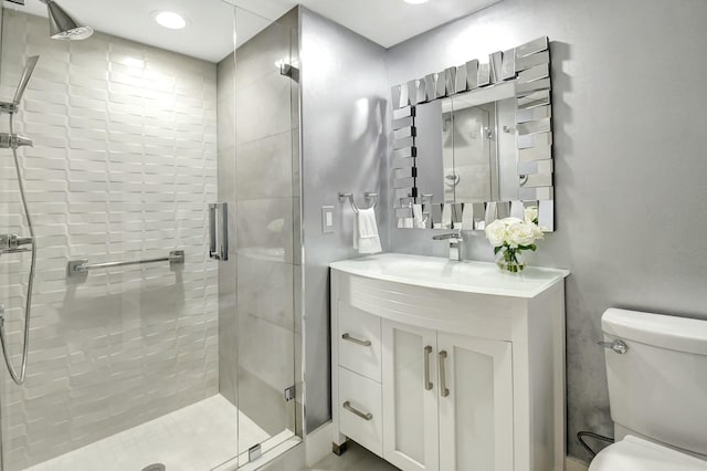 bathroom with toilet, a shower stall, and vanity