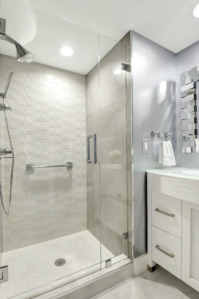 full bath with a shower stall, vanity, and tile patterned floors