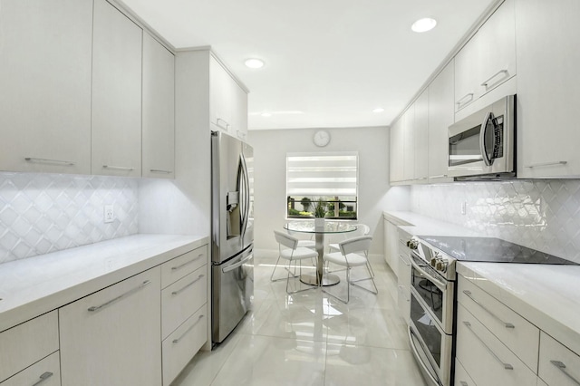 kitchen with light countertops, appliances with stainless steel finishes, backsplash, and recessed lighting