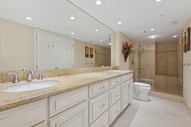 bathroom with toilet, a shower stall, visible vents, and a sink