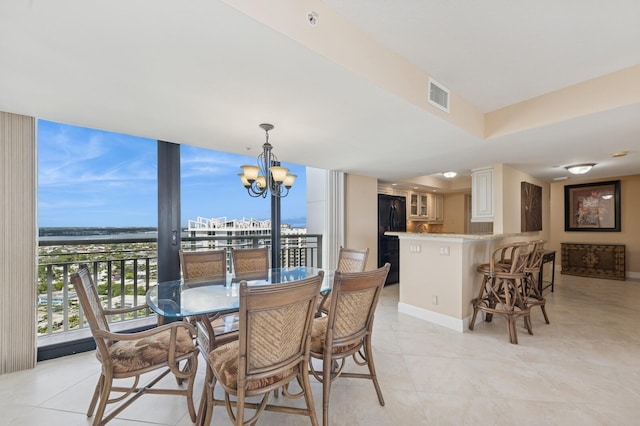 dining area featuring a chandelier, visible vents, baseboards, and light tile patterned floors