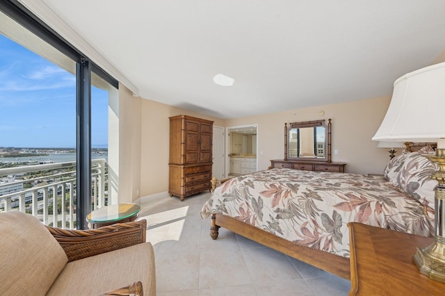 bedroom featuring light tile patterned floors, expansive windows, and connected bathroom