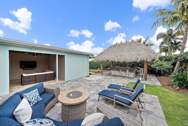 view of patio / terrace featuring a ceiling fan, outdoor dry bar, a gazebo, and an outdoor hangout area