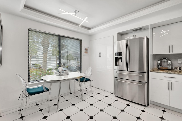 kitchen featuring stainless steel refrigerator with ice dispenser, light floors, a raised ceiling, visible vents, and white cabinets