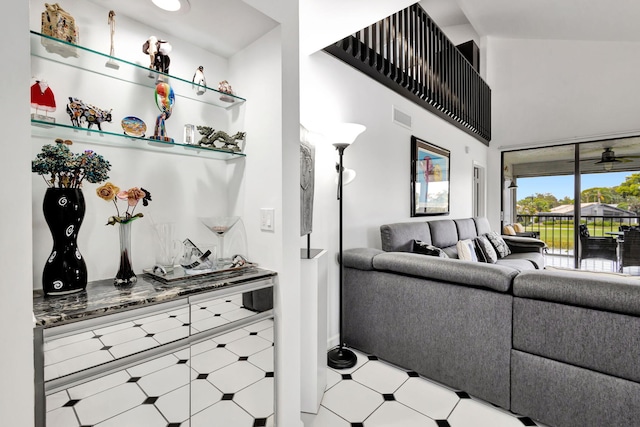 living area featuring a high ceiling, visible vents, and tile patterned floors