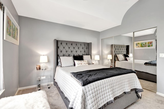 carpeted bedroom featuring a closet and baseboards