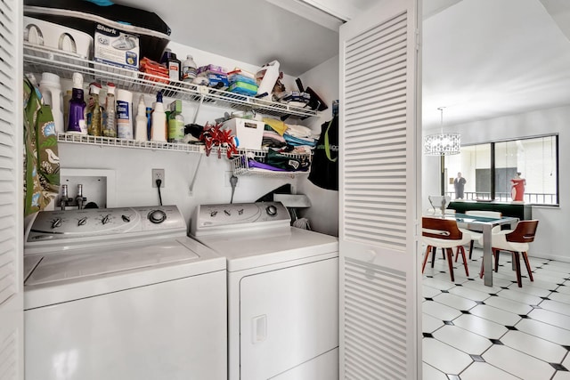 laundry room featuring laundry area, separate washer and dryer, a notable chandelier, and tile patterned floors