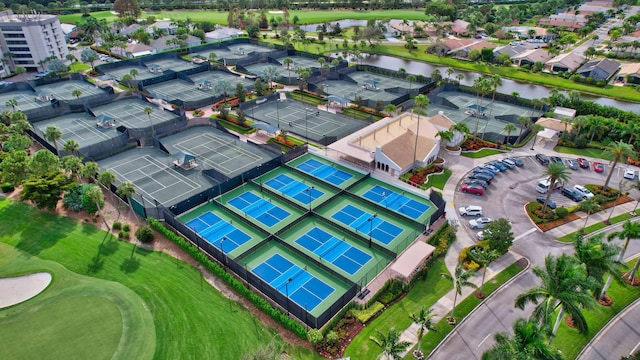 drone / aerial view with a water view, view of golf course, and a residential view