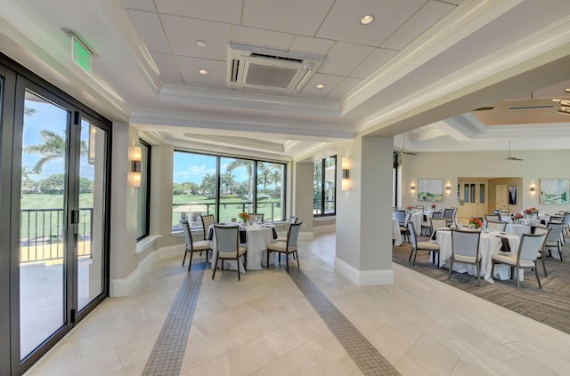 dining space with light tile patterned floors, a tray ceiling, baseboards, and crown molding