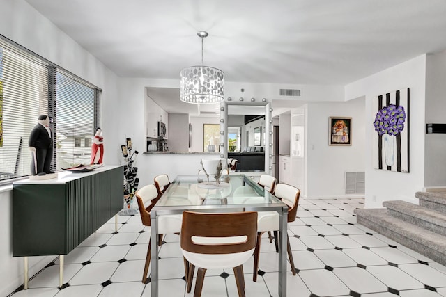 dining space with visible vents, a notable chandelier, stairway, and light floors