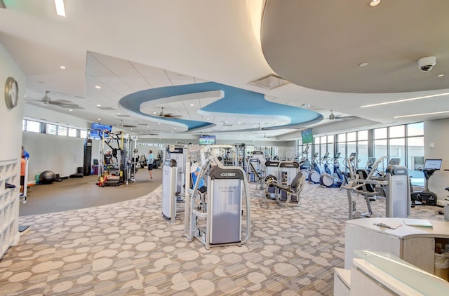 gym with ceiling fan, carpet flooring, a raised ceiling, and visible vents