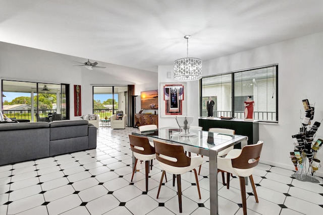 dining room with ceiling fan with notable chandelier, light floors, and baseboards