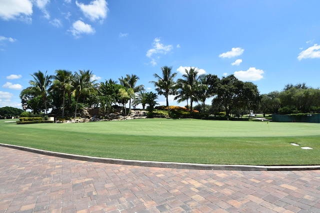 view of property's community with view of golf course and a lawn