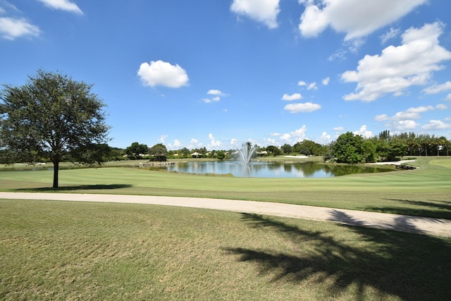 view of community featuring a water view, view of golf course, and a yard