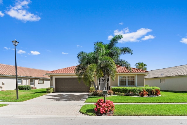 view of front of home featuring a garage, stucco siding, a tile roof, and a front yard