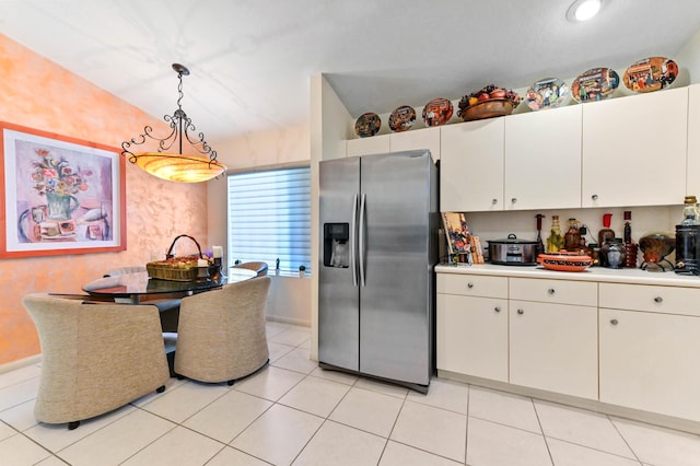 kitchen featuring light tile patterned flooring, white cabinetry, light countertops, stainless steel fridge with ice dispenser, and pendant lighting