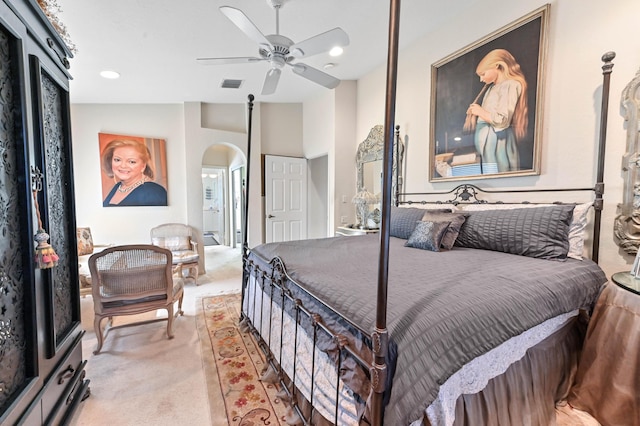 bedroom featuring arched walkways, ceiling fan, light colored carpet, visible vents, and vaulted ceiling