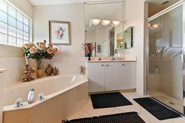 full bathroom featuring a garden tub, a shower stall, vanity, and tile patterned floors