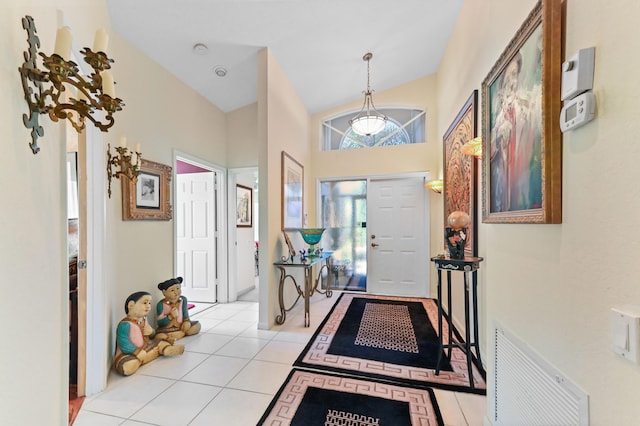 entryway with light tile patterned floors, a towering ceiling, and visible vents